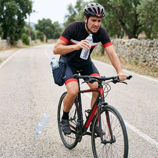Ciclista sin soporte sosteniendo la botella con la mano